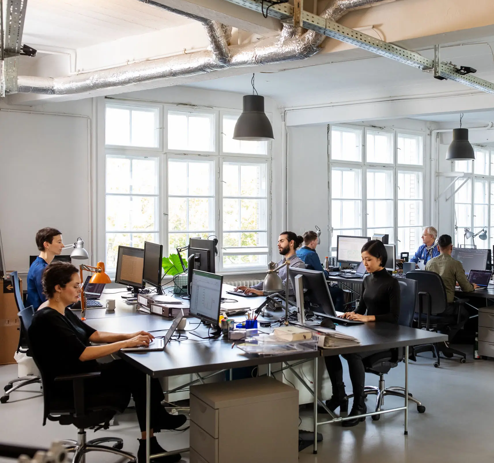 Casually dressed workers in a busy open plan office. Business people working at a modern office.